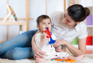 Nanny and Baby Smiling in Playroom